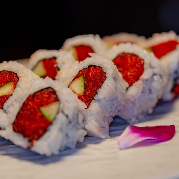 Close-up of Soho Japanese Restaurant's sushi rolls with red filling, cucumber, and white rice.