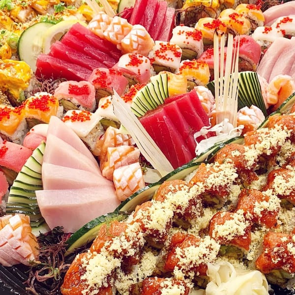 A vibrant platter of assorted Japanese sushi and sashimi, including tuna, salmon, and various rolls.